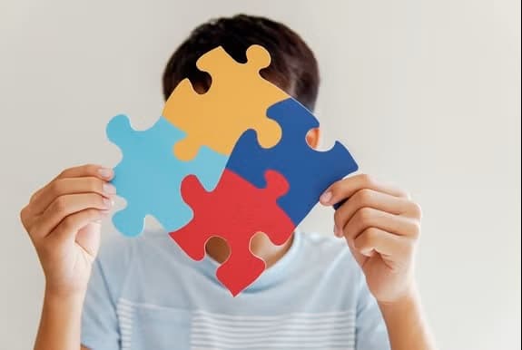 Person holding colorful jigsaw puzzle piece
