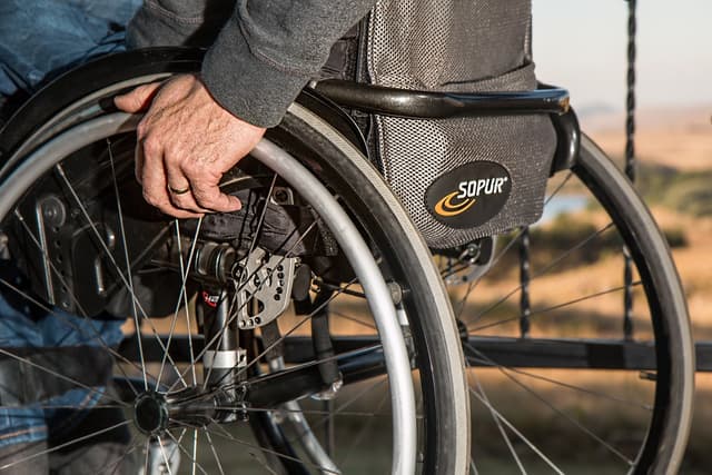 Person gripping wheelchair wheel
